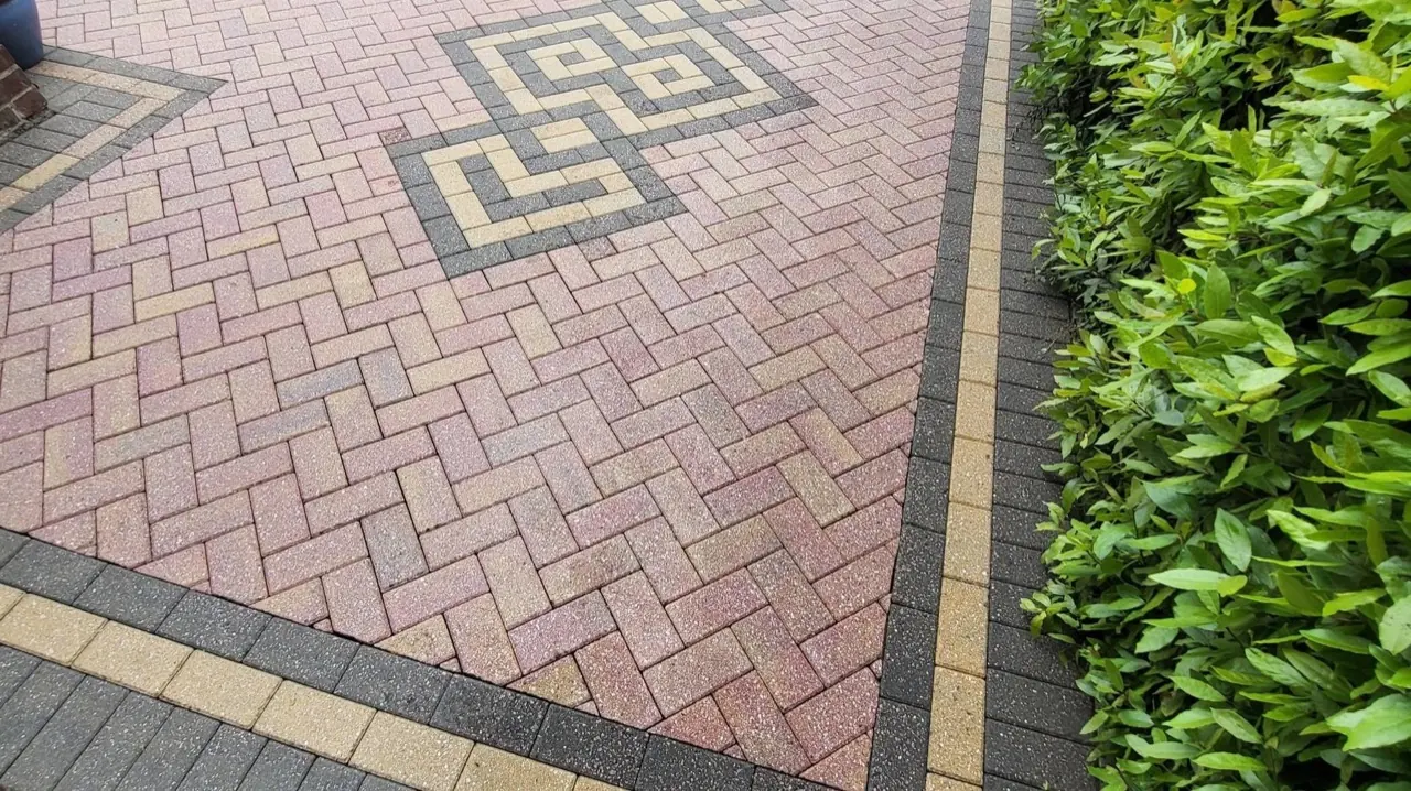 Block paved driveway in Poole after pressure washing, clean paving running up to a green hedge